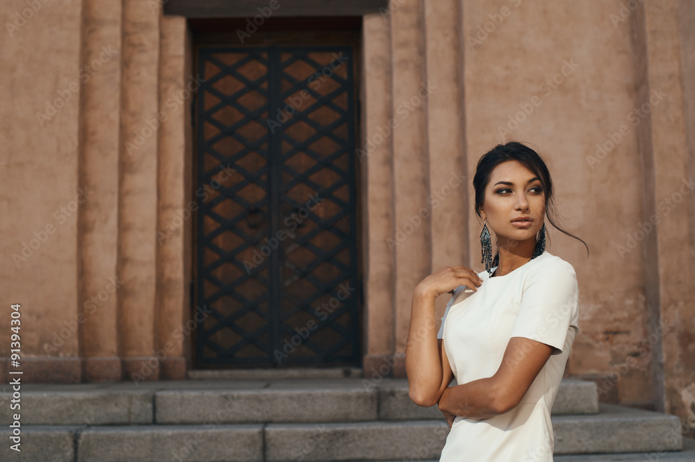 Fototapeta premium lady in dress against ancient building with thoughtful look
