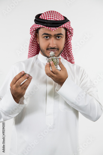 Portrait of Arab man smelling perfume. photo