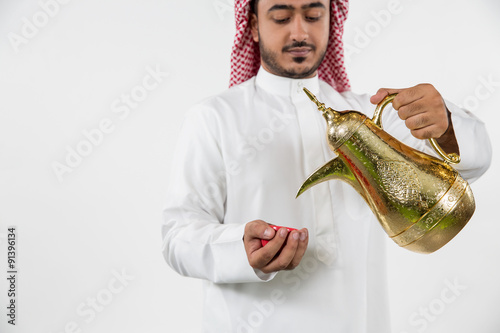 Arab man pouring coffee into cup. photo