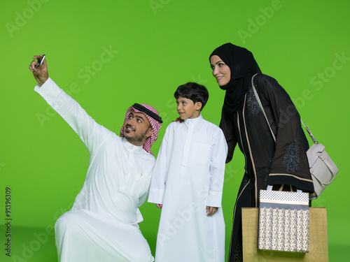 Arab family taking selfie using mobile camera. photo