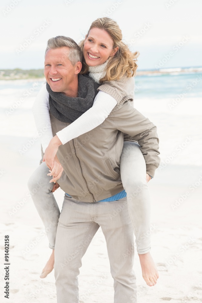 Smiling man giving woman a piggy back Smiling man giving woman a piggy back