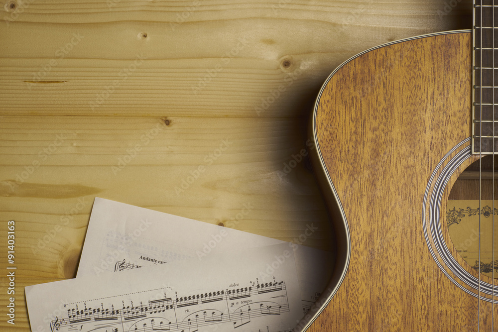Naklejka premium Guitar and Sheet music on wood.