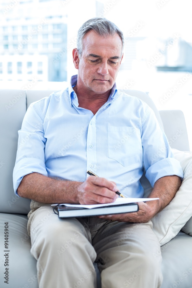 Businessman writing on notepad at office Businessman writing on notepad at office
