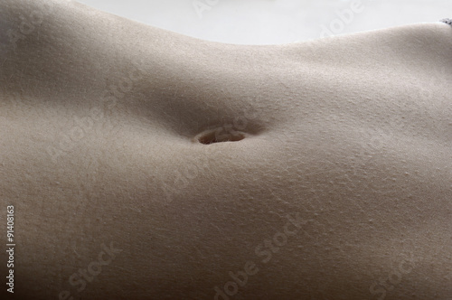 detail the navel of a woman with white background photo