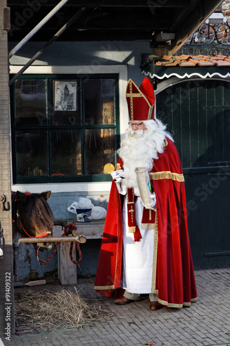 Saint Nicholas and his little horse in an old village
