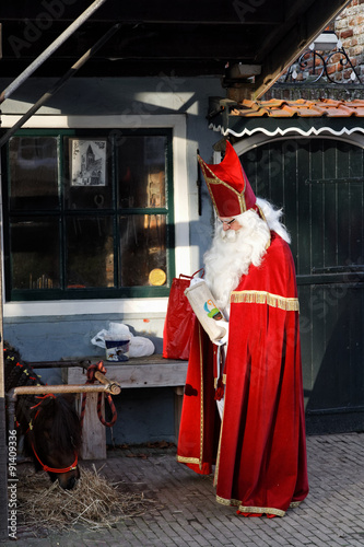 Saint Nicholas in front of an old house photo