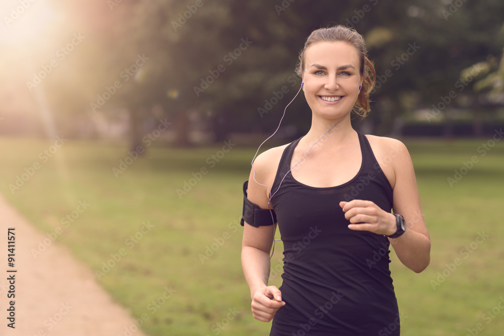 Hübsche Frau macht Jogging im Park mit Smartphone Hübsche Frau macht Jogging im Park mit Smartphone