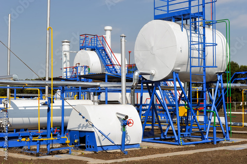 White fuel tanks in natural gas treatment plant in bright sunny summer day photo