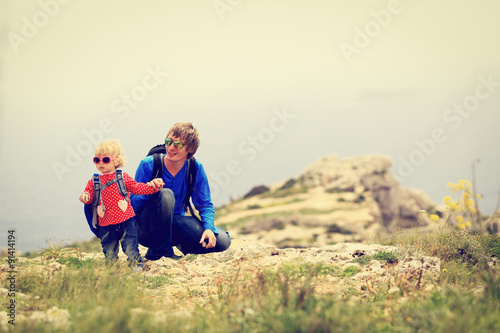 father and little daughter hiking in mountains