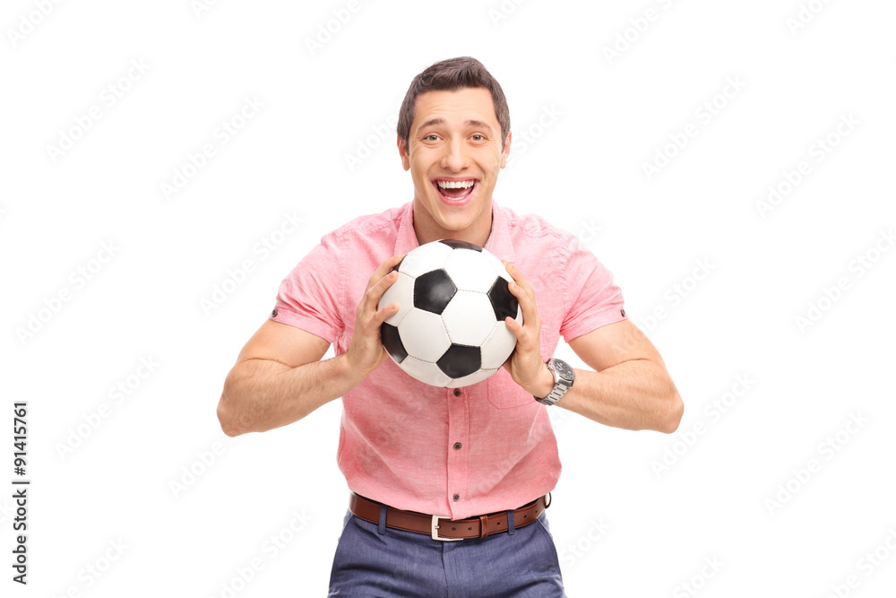 Joyful young guy holding a football