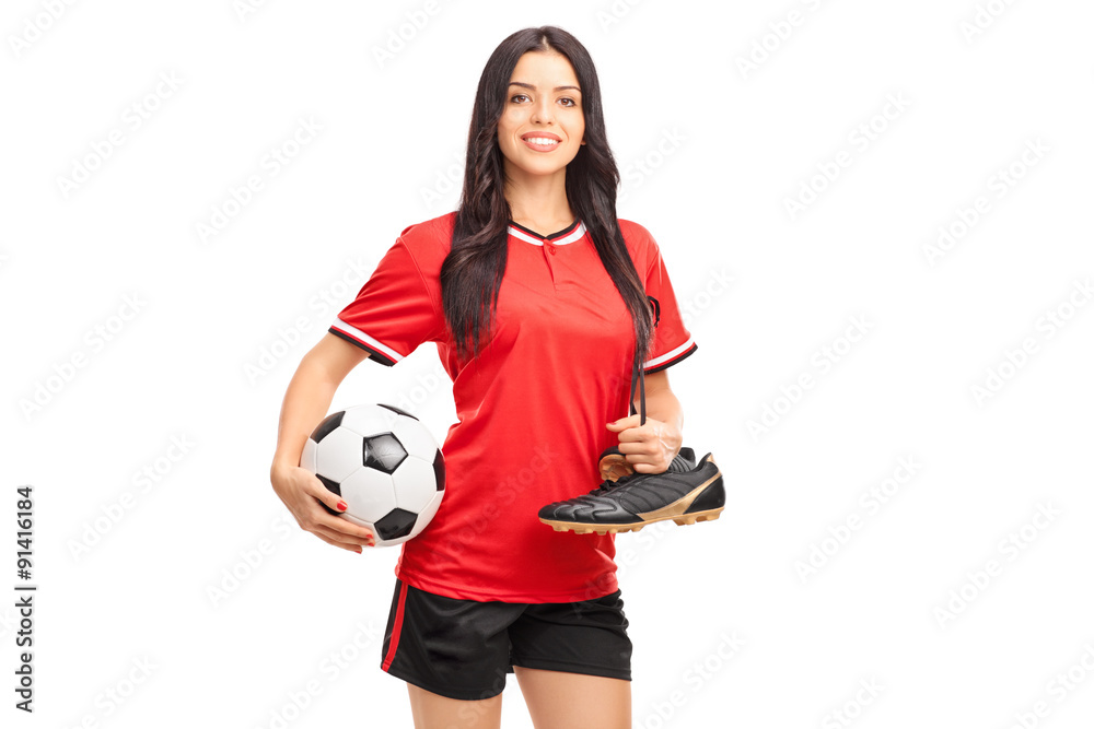 Young female soccer player holding a ball