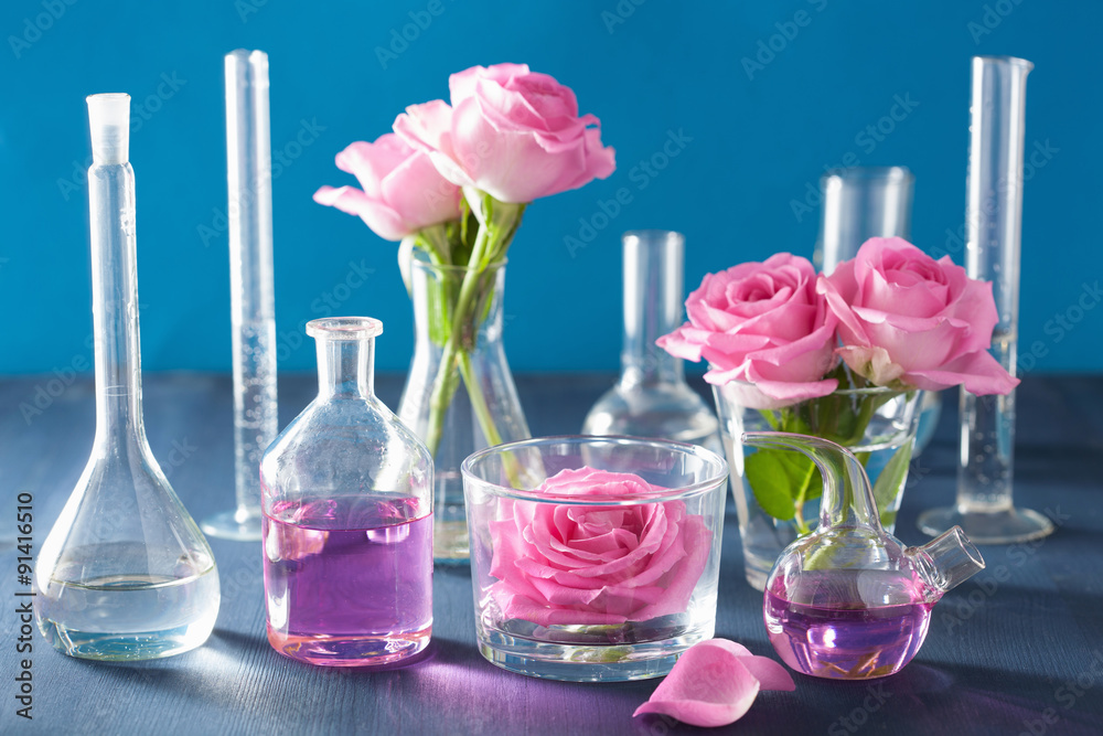 alchemy and aromatherapy set with rose flowers and chemical flas