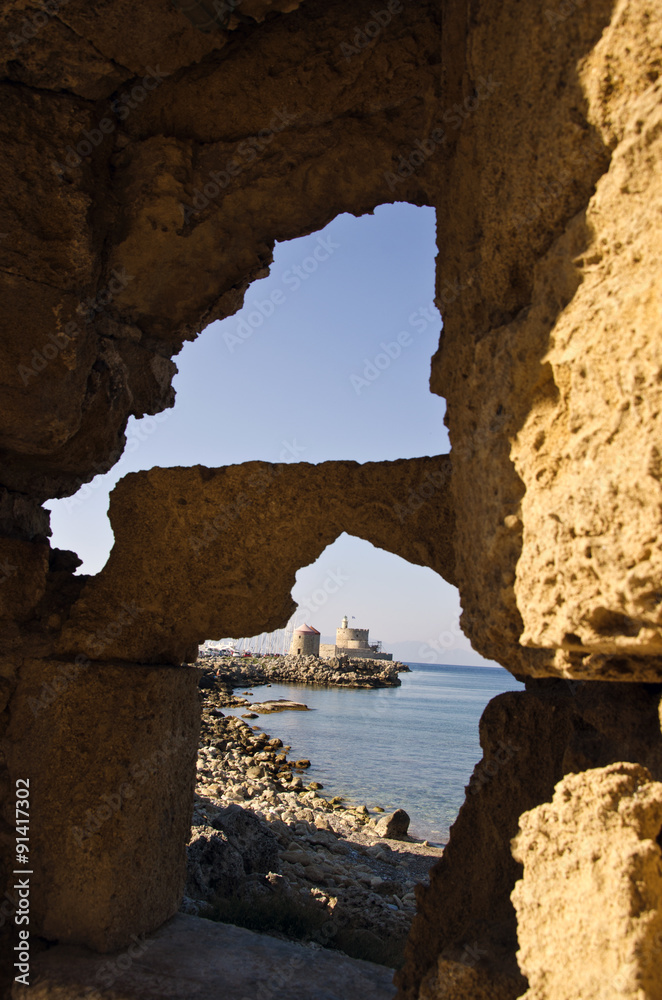 Fortress seen through the holes in cliffs in Rhodes island