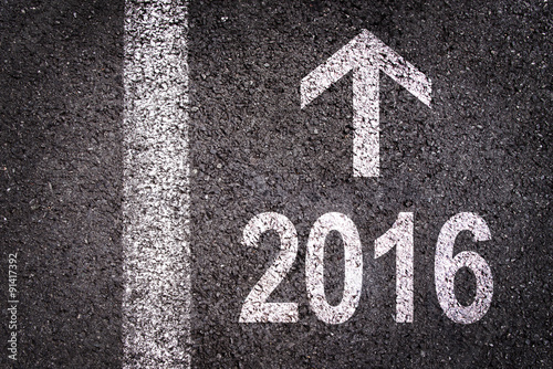 2016 and an arrow written on an asphalt road background