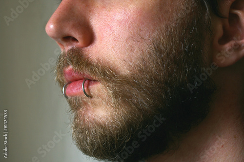 Close up of a mans face with a piercing