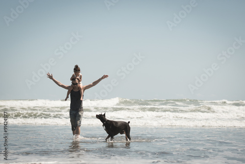 海で遊ぶ親子と犬