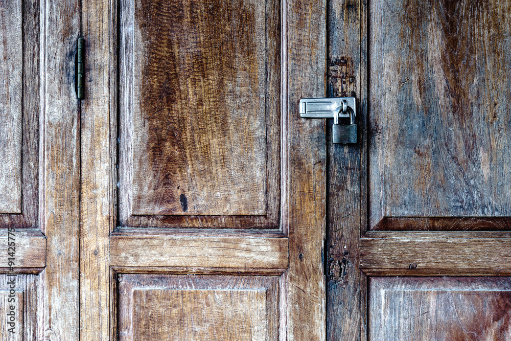 Old padlock on a wooden door Old padlock on a wooden door