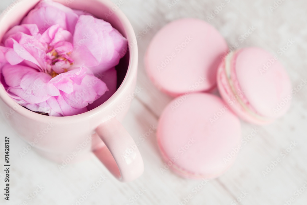 Tea cup with rose and macaroons, selective focus