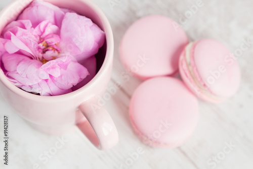 Tea cup with rose and macaroons  selective focus