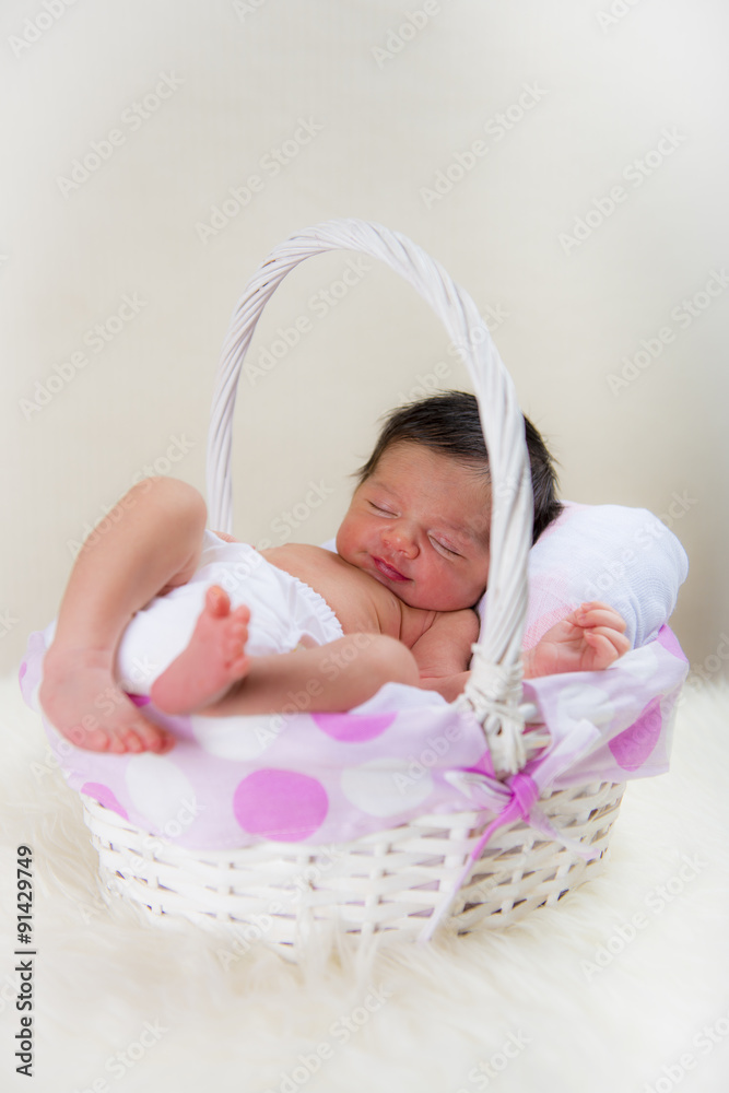 Bebé recién nacido niña relajada en calma dormida en una cesta blanca y  rosa sobre una manta de pelo Stock-bilde
