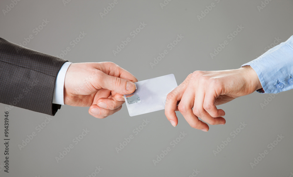 Business people passing a plastic card each other