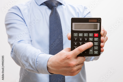 Businessman holding a calculator and counting