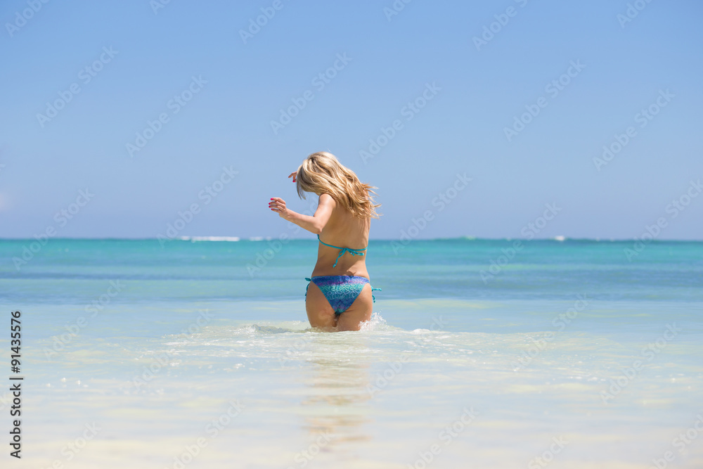 Cheerful woman running into water