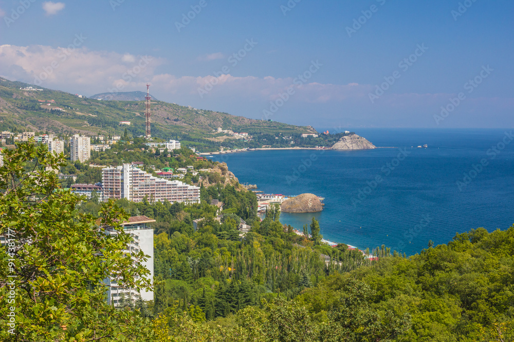 Small town on the Black Sea coast against blue sky with clouds.