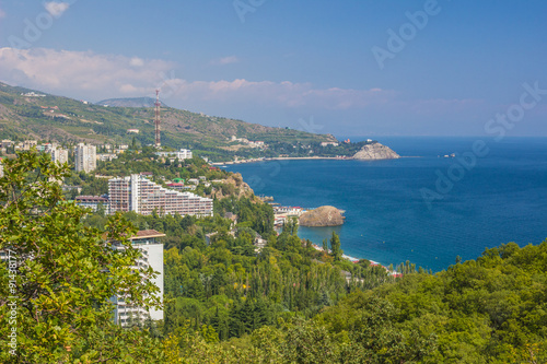 Small town on the Black Sea coast against blue sky with clouds.