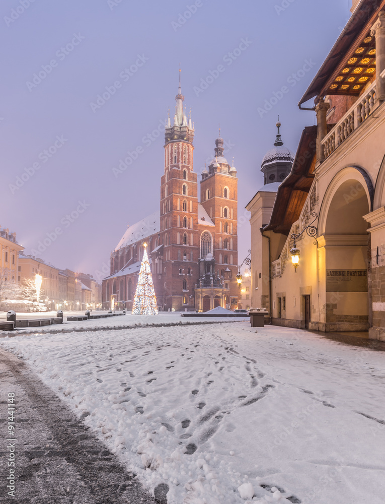 Naklejka premium Krakow, Poland, St Mary's church and Sukiennice (Cloth hall) on the Main Market Square in heavy snow