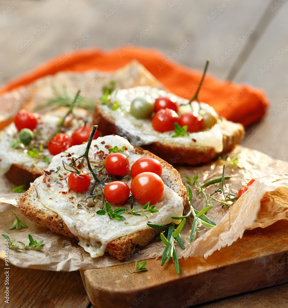 Bruschetta with cheese, cherry tomatoes and aromatic herbs Bruschetta with cheese, cherry tomatoes and aromatic herbs