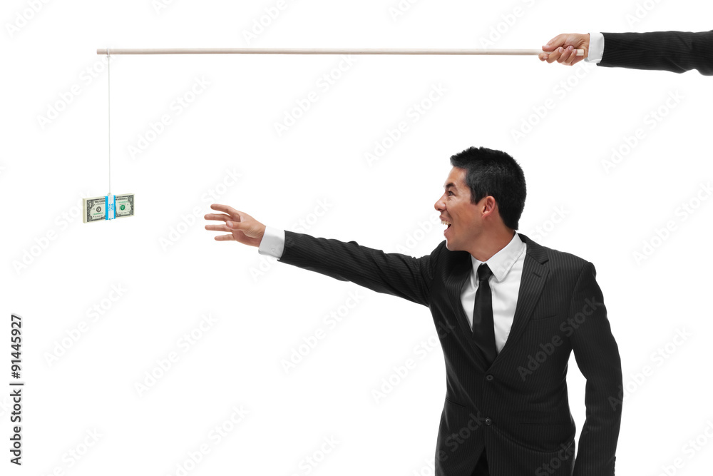 Excited businessman reaching for a stack of money on the end of Excited businessman reaching for a stack of money on the end of