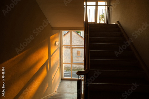 Staircase of apartment building with sunset light playing on the photo