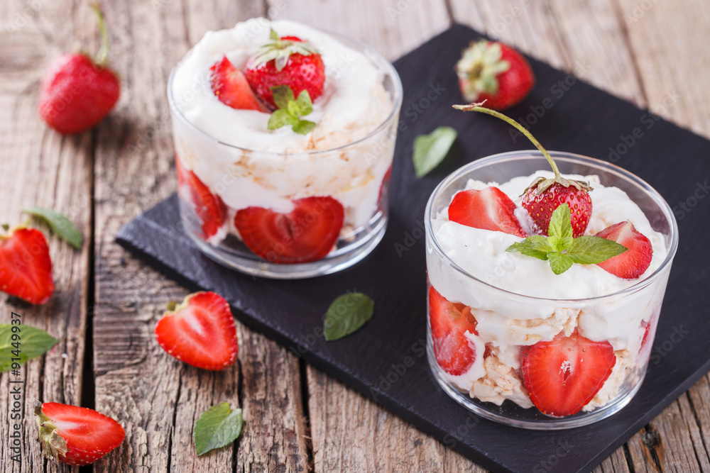 Eton Mess - Strawberries with whipped cream and meringue in a glass beaker. Classic British summer dessert.selective focus