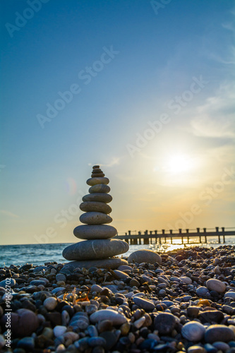 Turret pebbles at sunset with ocean on background and a quay