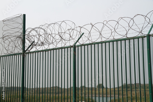 Green fence with razor wire guarding French ferry terminal. © Andy Chisholm