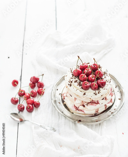 Pavlova cake with fresh cherry, cheese cream and chocolate chips photo