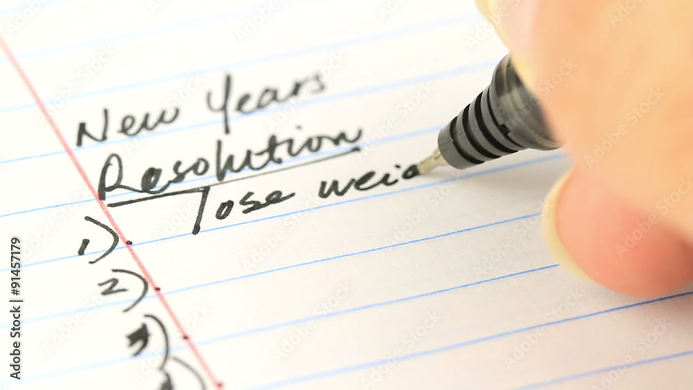 writing down your new years resolutions on paper - different angle