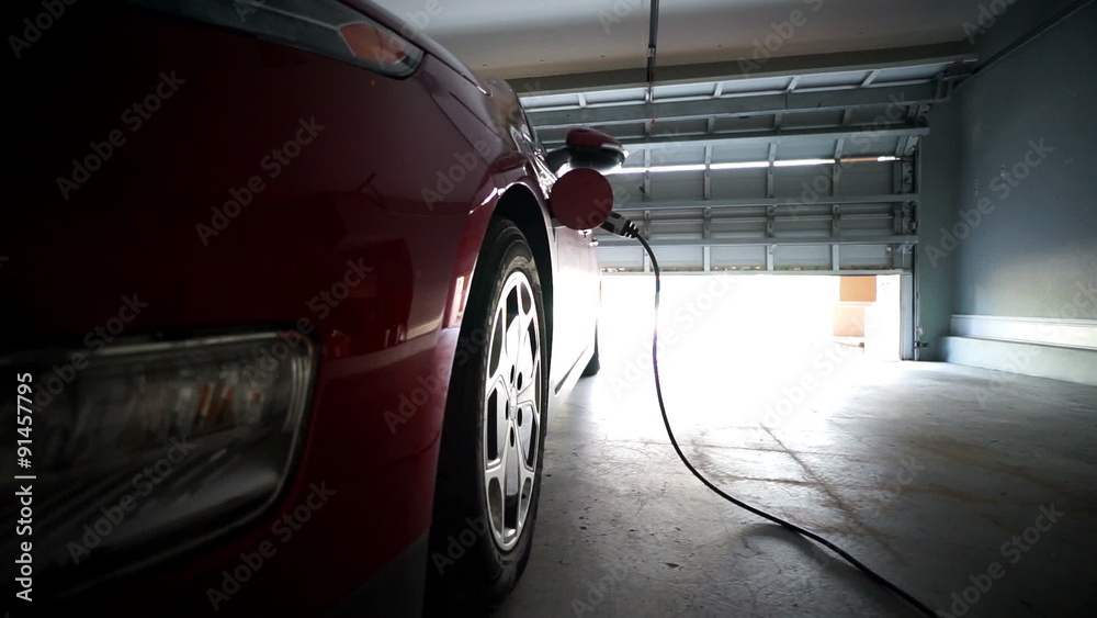 electric vehicle charges in garage - dramatic angle