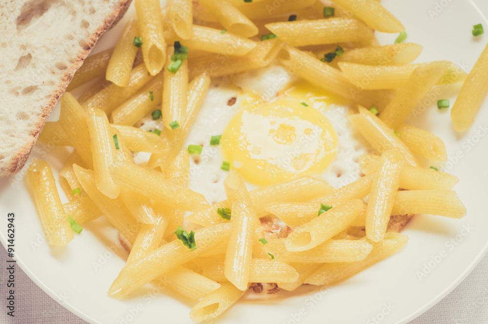 Fried eggs with penne pasta and ciabatta