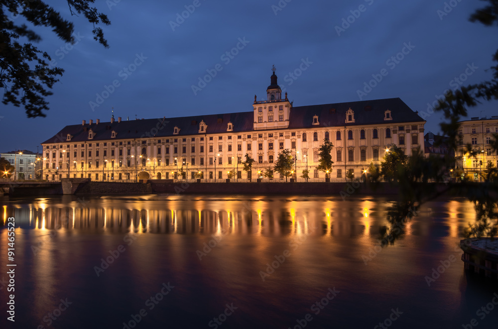 Odra river waterfront in Wroclaw, Poland, with main university building, in early morning, seen from University Bridge