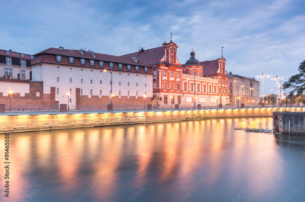 Odra river waterfront in Wroclaw, Poland, with Ossolineum museum and library and university building, in early morning, seen from Sand Island (Wyspa Piasek)