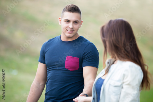 Young couple holding hands in park