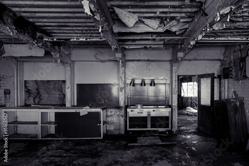 Black and white derelict abandoned kitchen, with severely ruined ceiling
