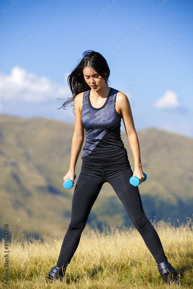 Exercising fitness woman doing exercises in nature. Girl doing m Exercising fitness woman doing exercises in nature. Girl doing m