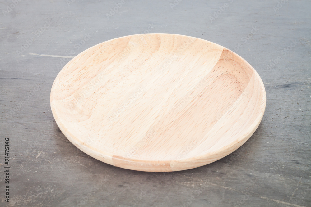 Wooden plate on grey background Wooden plate on grey background