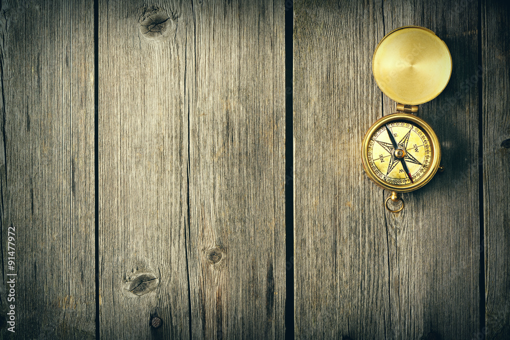 Fototapeta premium Antique compass over wooden background