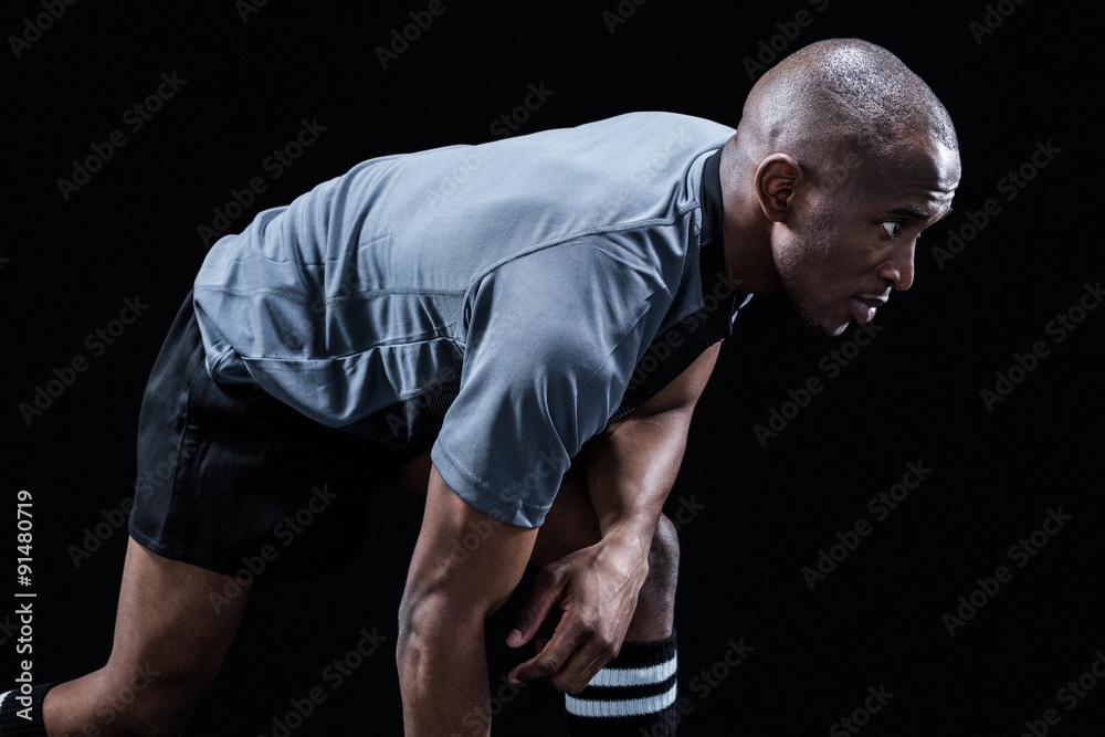 Determined sportsman bending while playing rugby Determined sportsman bending while playing rugby