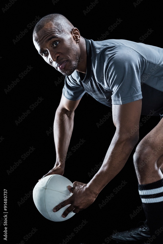 Rugby player looking away while holding ball Rugby player looking away while holding ball