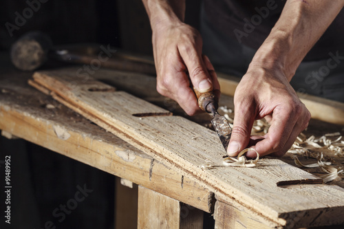 Fototapeta carpenter hands working with a chisel and carving tools